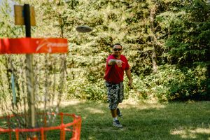 Disc Golf throwing a disc into the basket